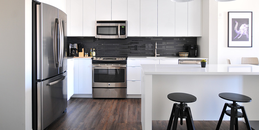 Image of newly renovated kitchen with hardwood floors and new cabinet.