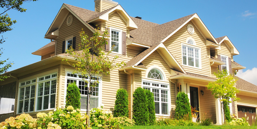 Image of large yellow house against a blue sky.