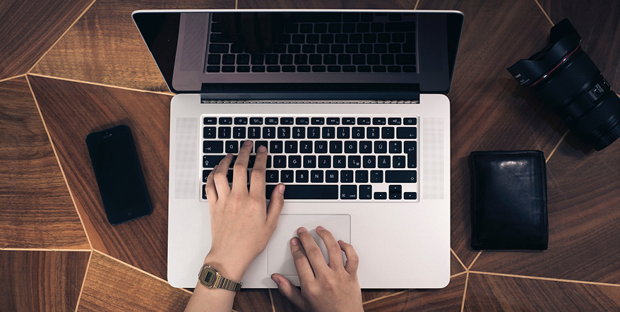 Image of hands on a laptop keyboard.