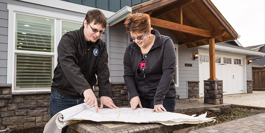 Image of home buyers looking over architectural plans.