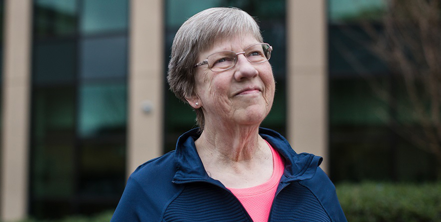 Image of cancer survivor Lynette Nielsen in front of cancer center in Roseburg.