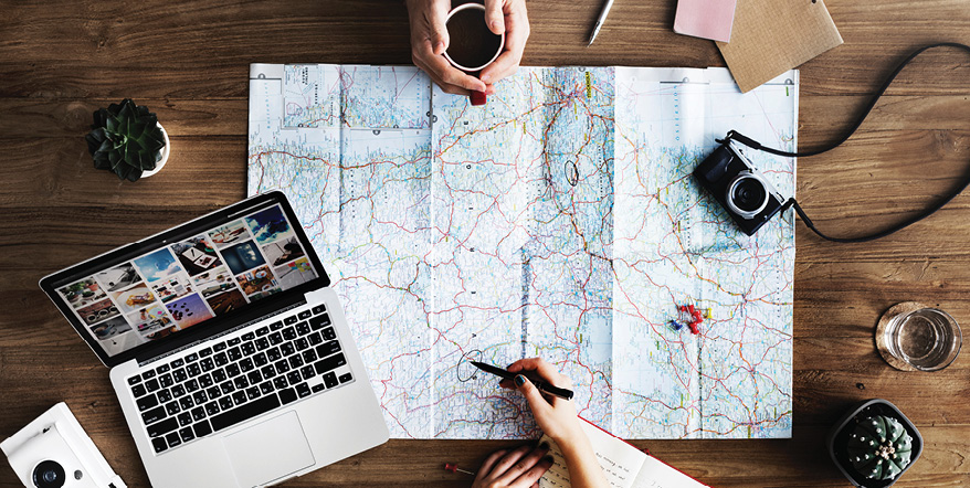 Image of two people planning a trip out on a map.