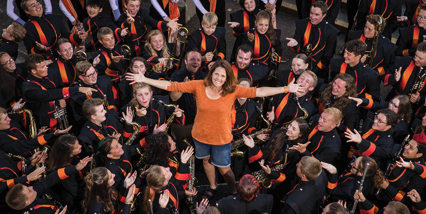 Image of Lori Adams standing in the middle of several Roseburg High School band students.