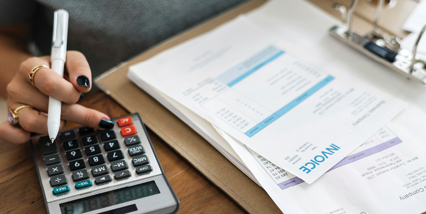 Image of woman with invoices and calculator.