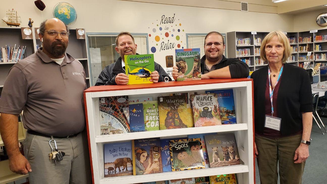 Members of IT donating a bookshelf