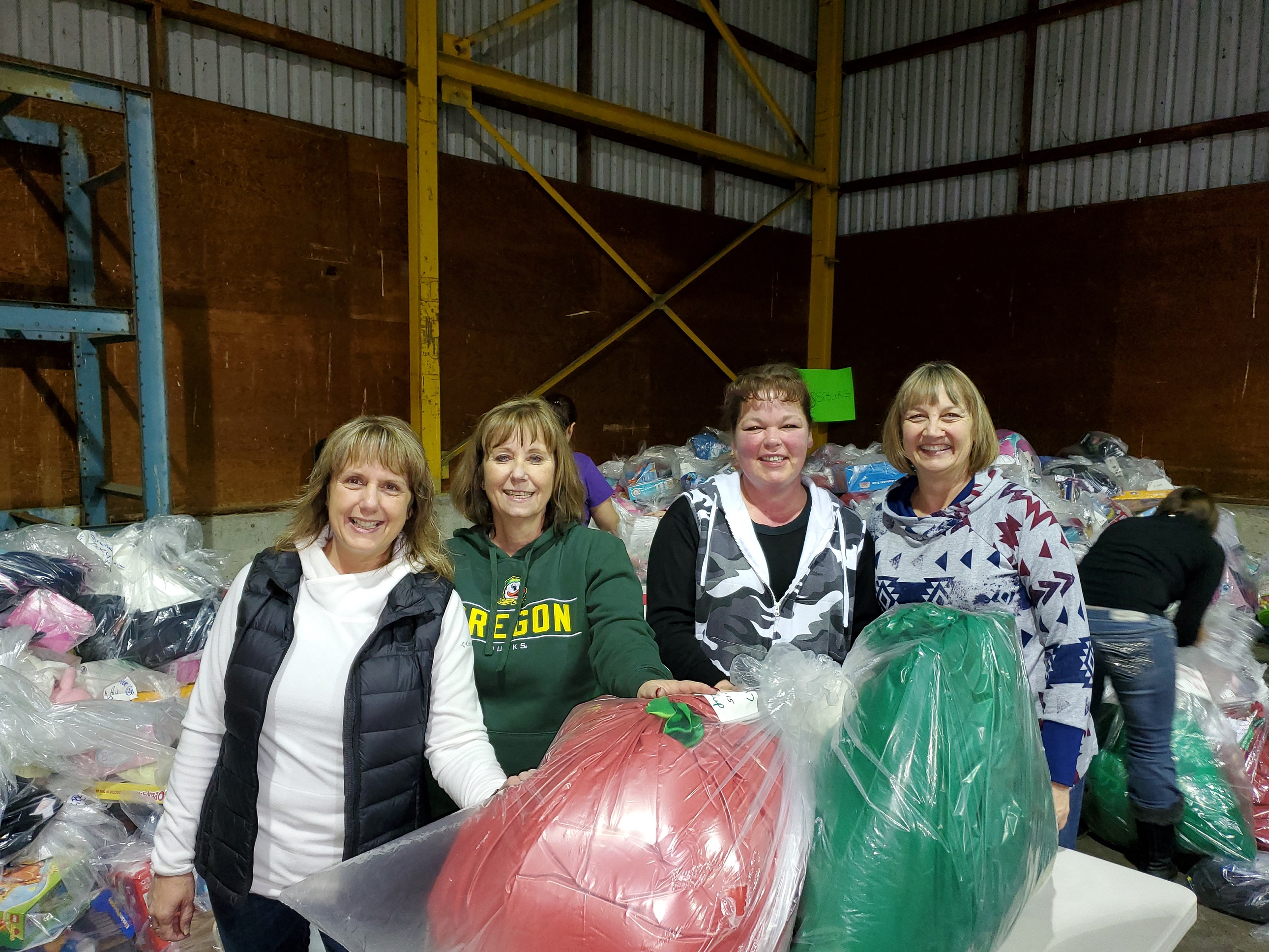 Roseburg branch managers and staff bag gifts for Christmas for Kids of Douglas County