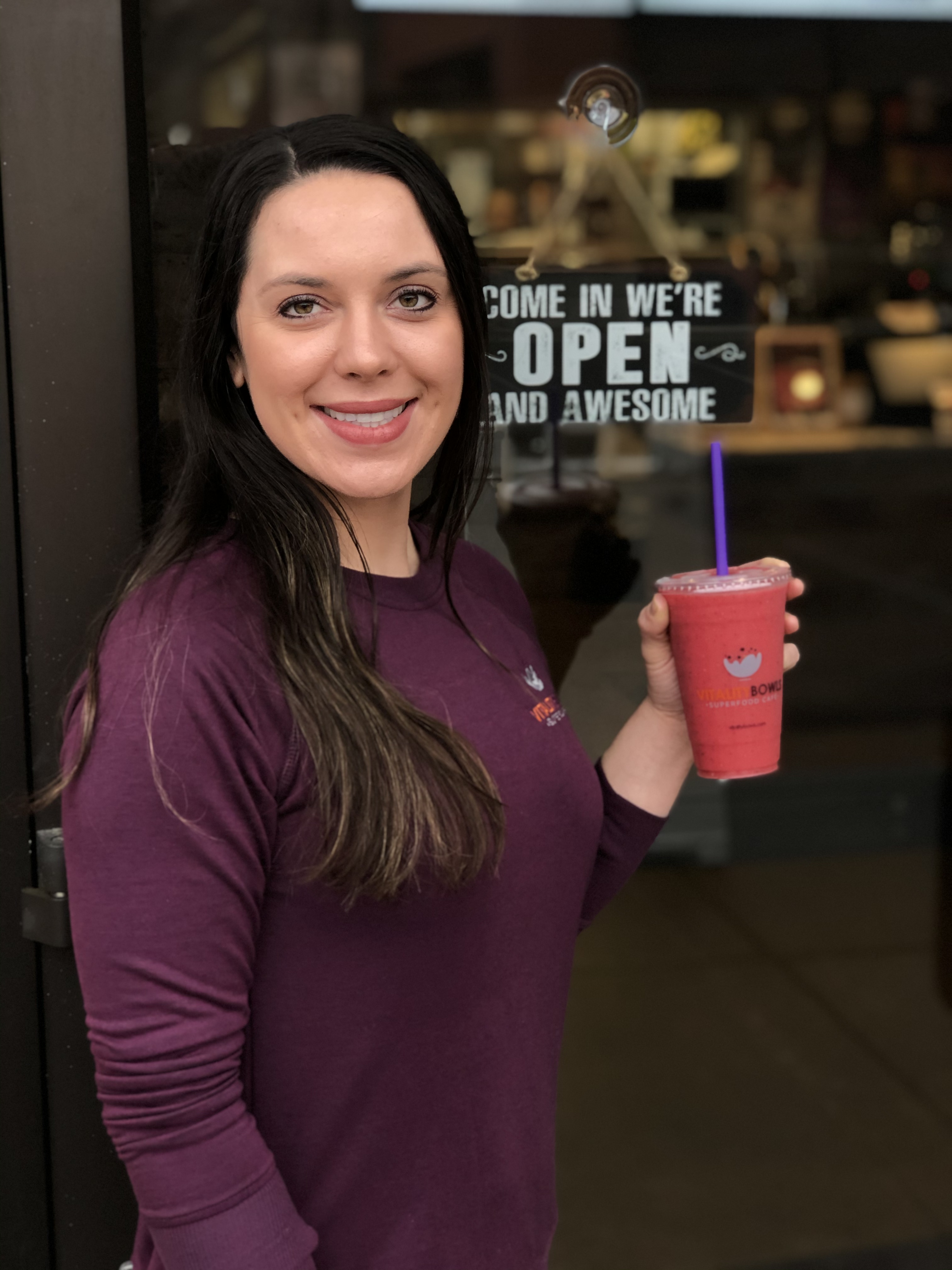 Jessica with a smoothie in front of her Vitality Bowls franchise